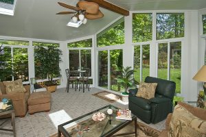 A sunroom with a coffee table and furniture on a sunny day